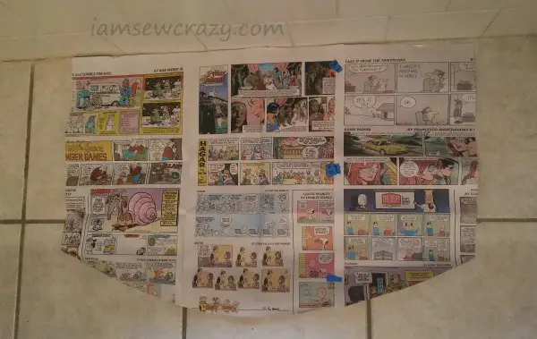 newspaper cut into a template to make a bath mat