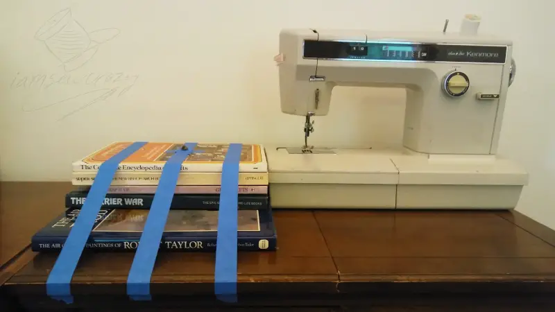 books taped to table next to sewing machine