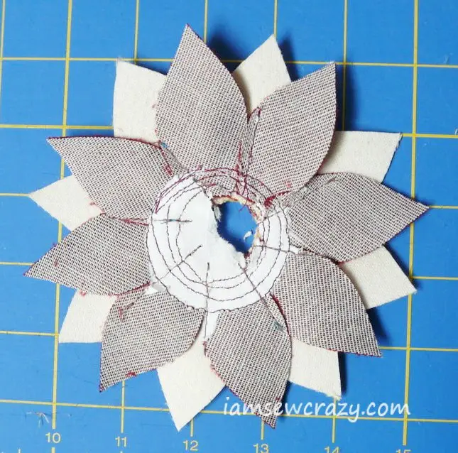 tearing paper away from the back of the fabric flower