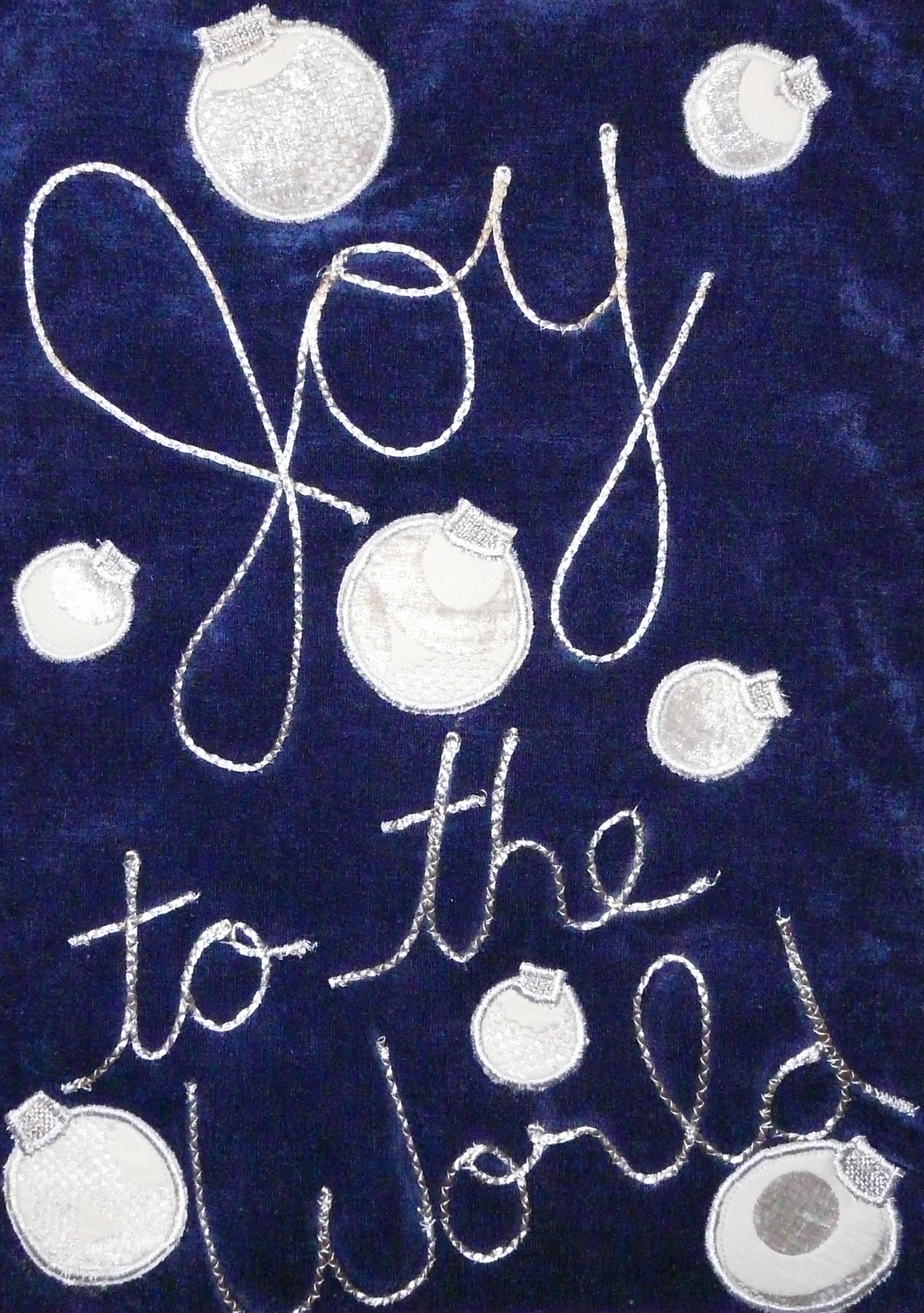 blue velvet wall hanging with couched silver text: Joy to the World