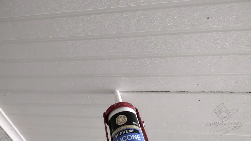 adding caulk to gap in ceiling panels to conceal joint