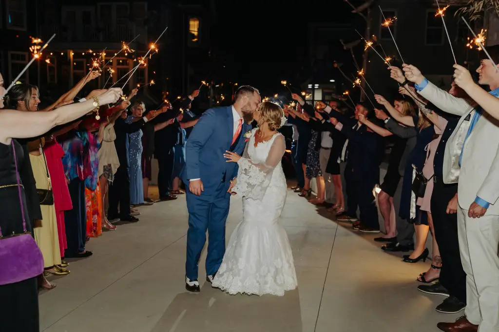 bride and groom kissing under sparklers at wedding reception