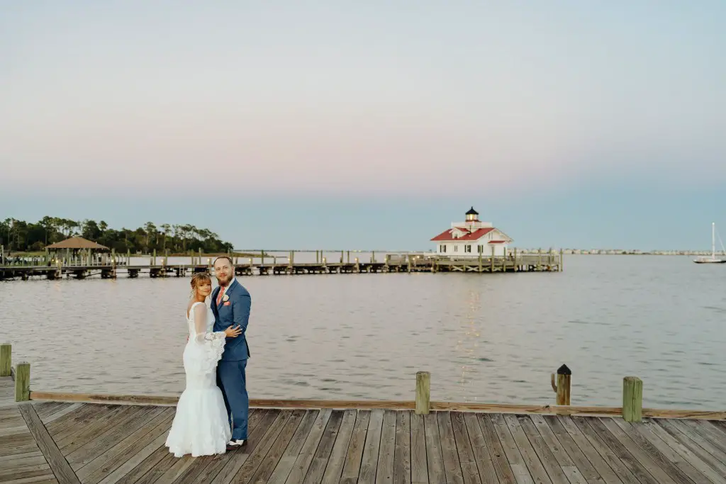 bride standing with groom on dock