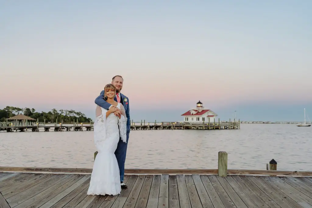 bride and groom embracing on pier