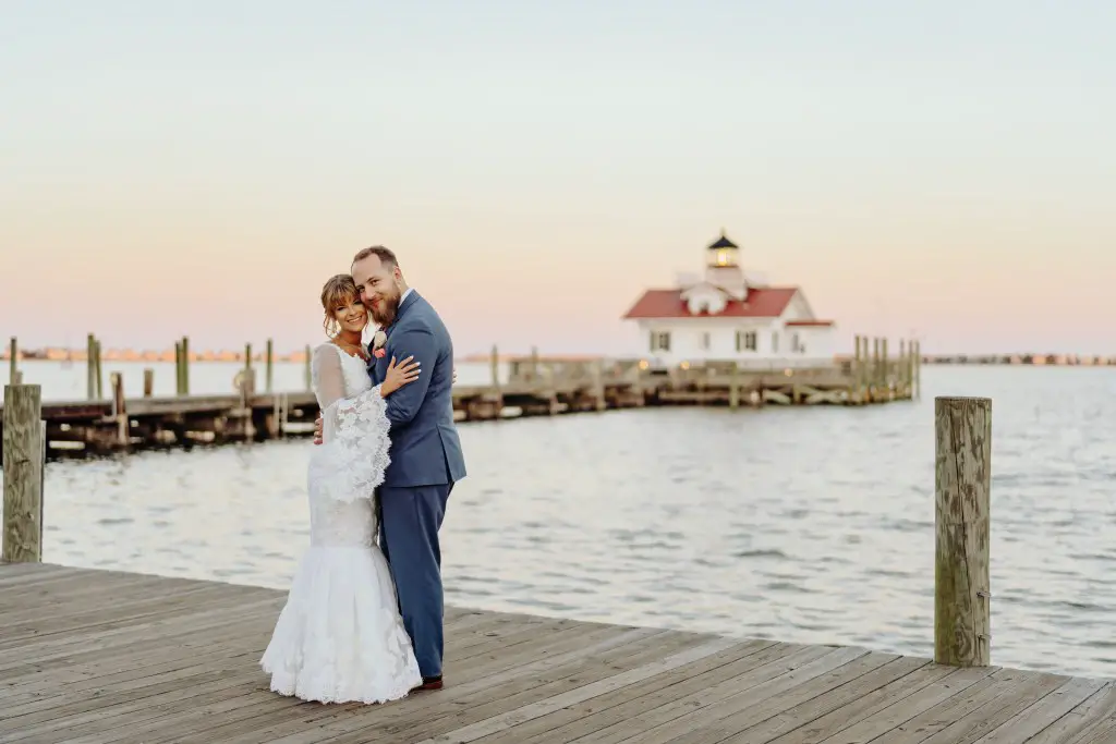 bride and groom in front of lighthouse