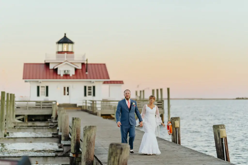 bride and groom walking away from lighthouse