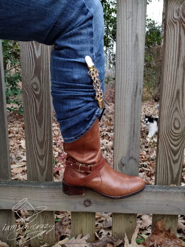 boot resting on fence with photobombing cat in background