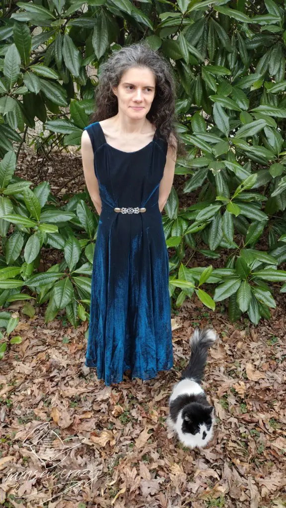 cat posing in front of lady wearing dress