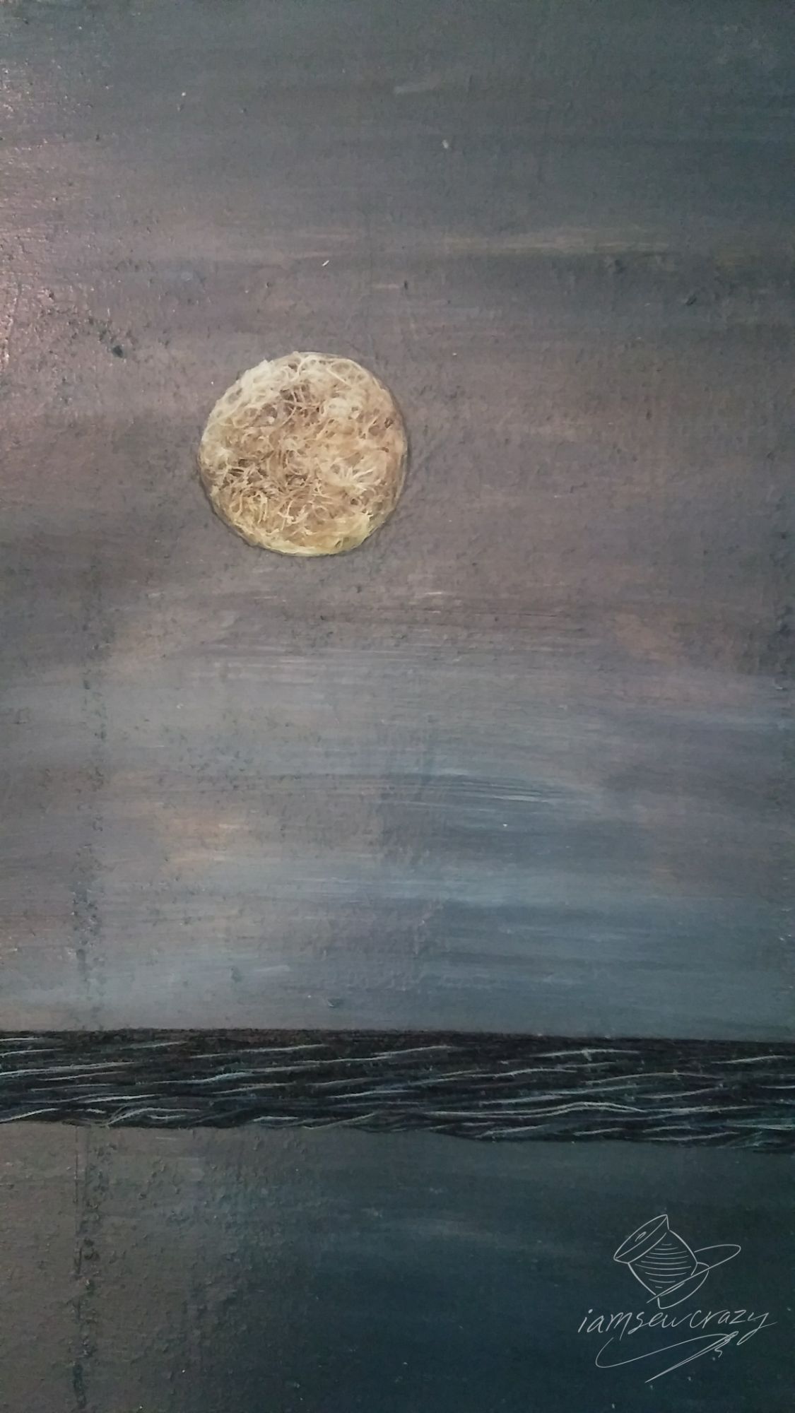 sewing thread decoupaged onto a board depicting ocean waves and the moon