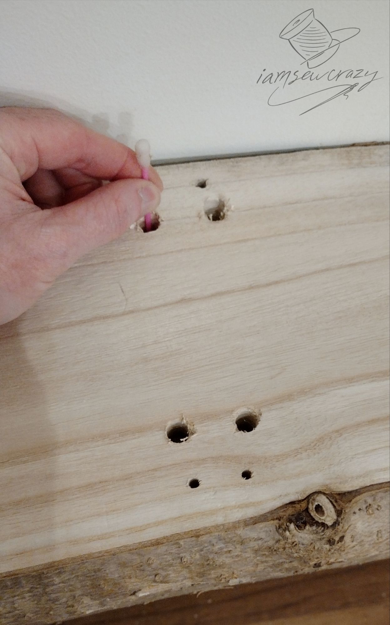 using a wet cotton swab to mark where to drill holes in board