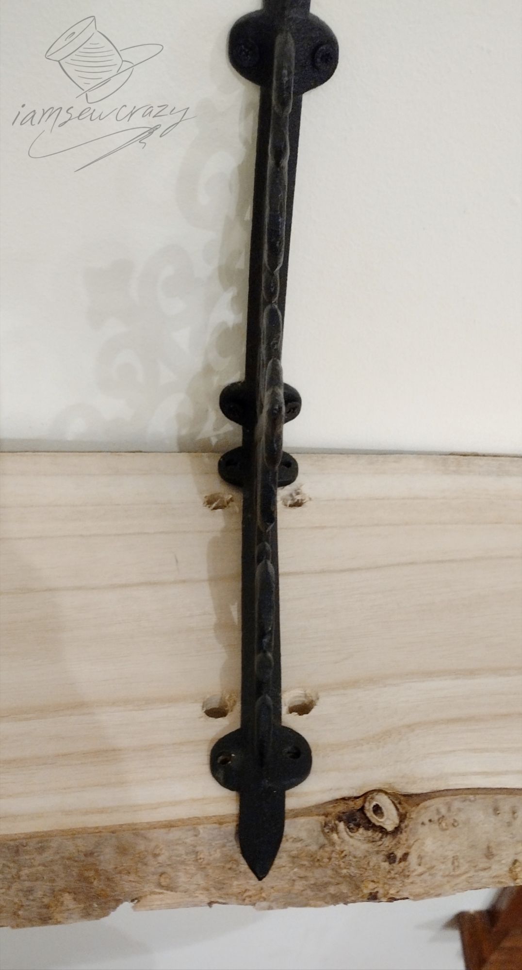 live edge wooden shelf bolted to cast iron brackets