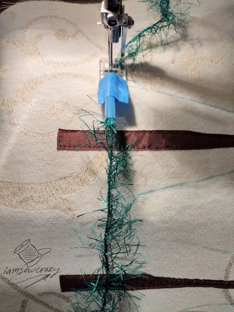 sewing over green eyelash yarn to create christmas tree branches
