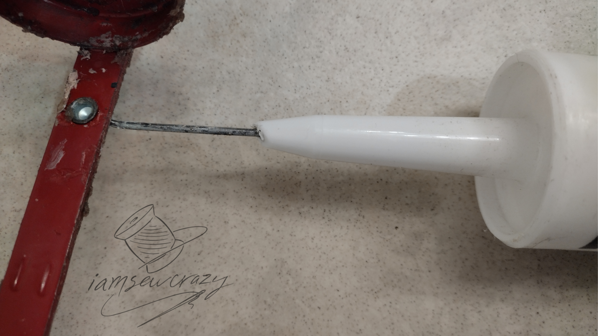 poking wire into tube of caulk to break foil seal